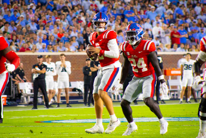 Jaxson Dart and Ulysses Bentley red jersey and blue helmet